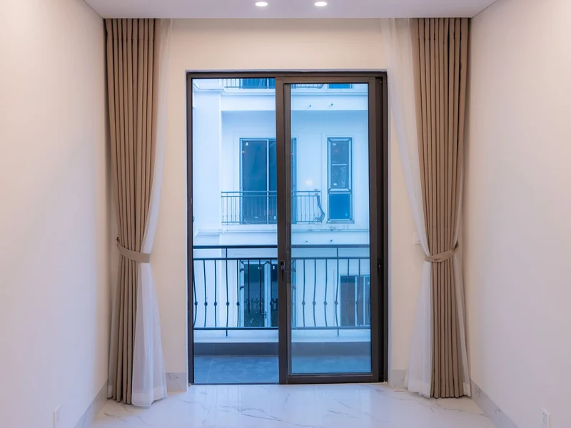 Two-panel aluminium sliding glass door with a fixed screen and curtains