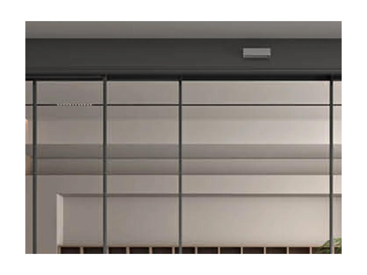 Close view of the head rail over the glass leaves of the electric sliding door, with the recessed sensing unit