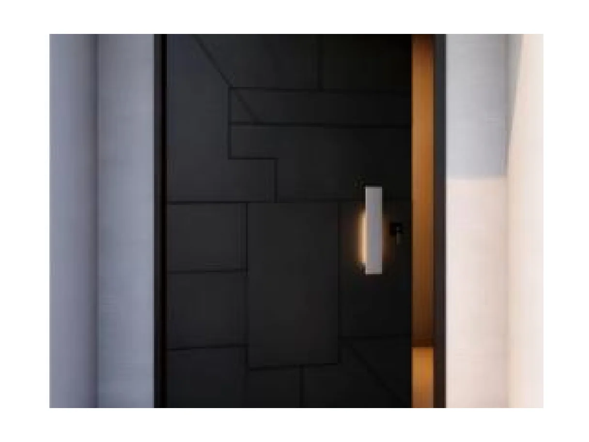 Front view of a black aluminium offset-hinge entrance leaf with a faceted geometric face and a brass pull