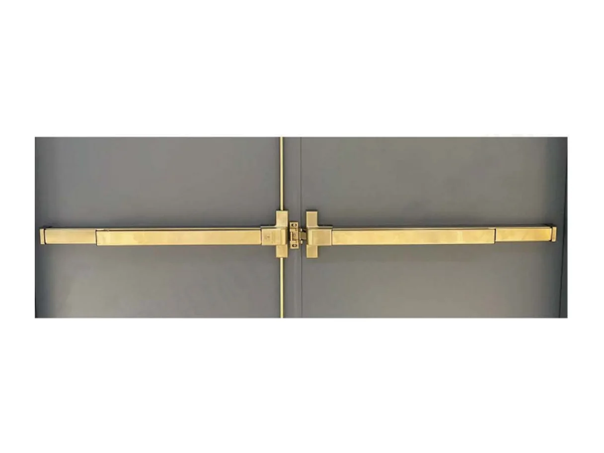 Full-width horizontal panic bar running across a pair of metal fire door leaves