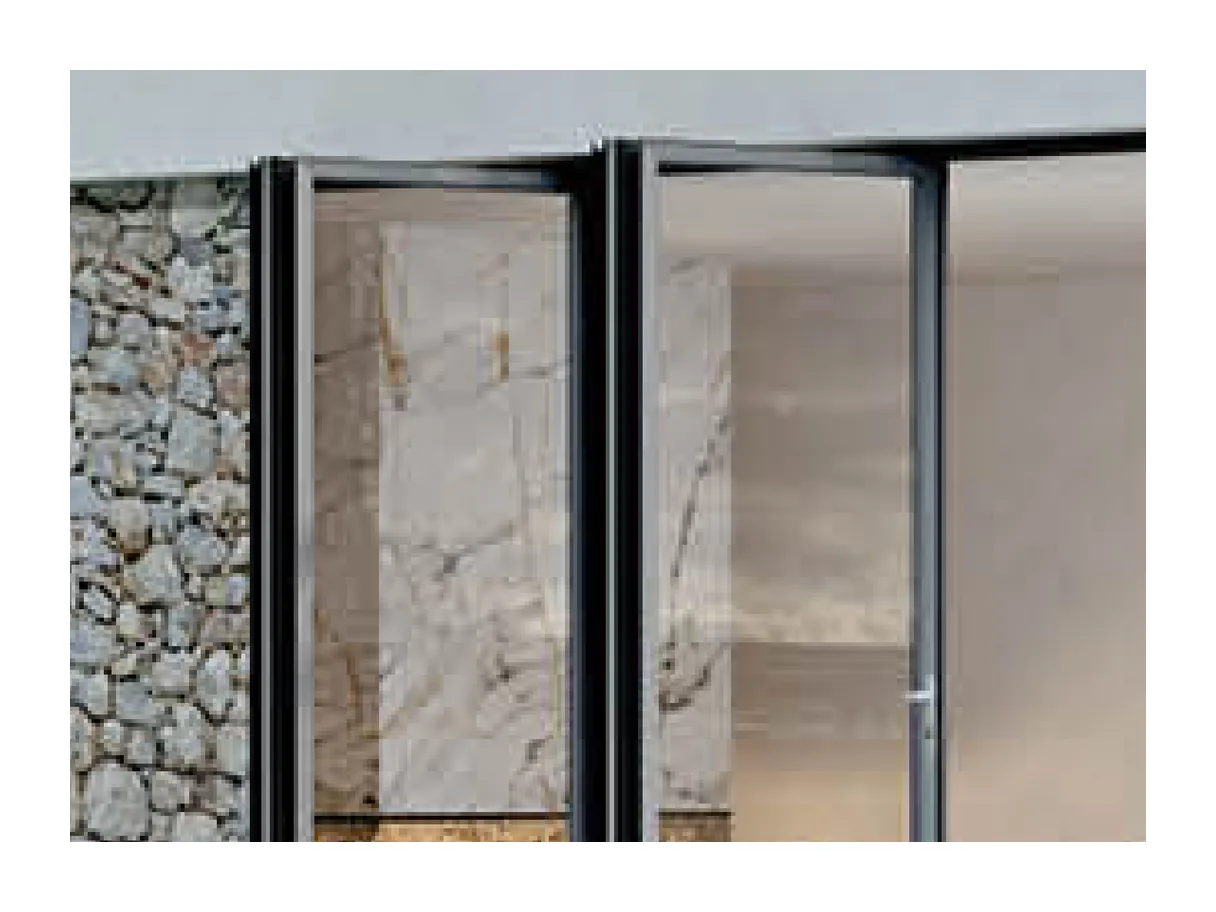 Close view of two folded aluminium door leaves with clear glass against a stone-clad wall