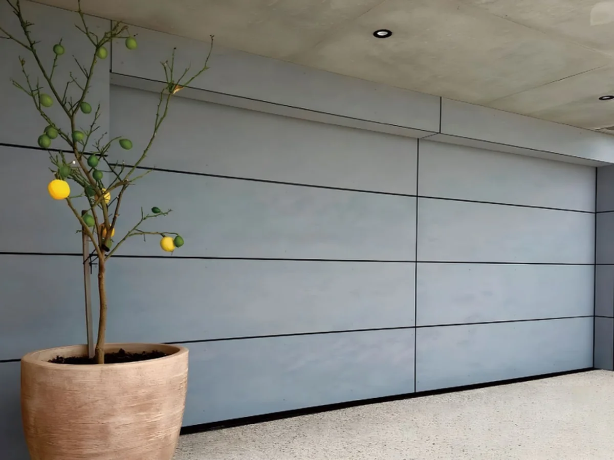 Flat aluminium flush panel garage door on a rendered modern facade, design rendering