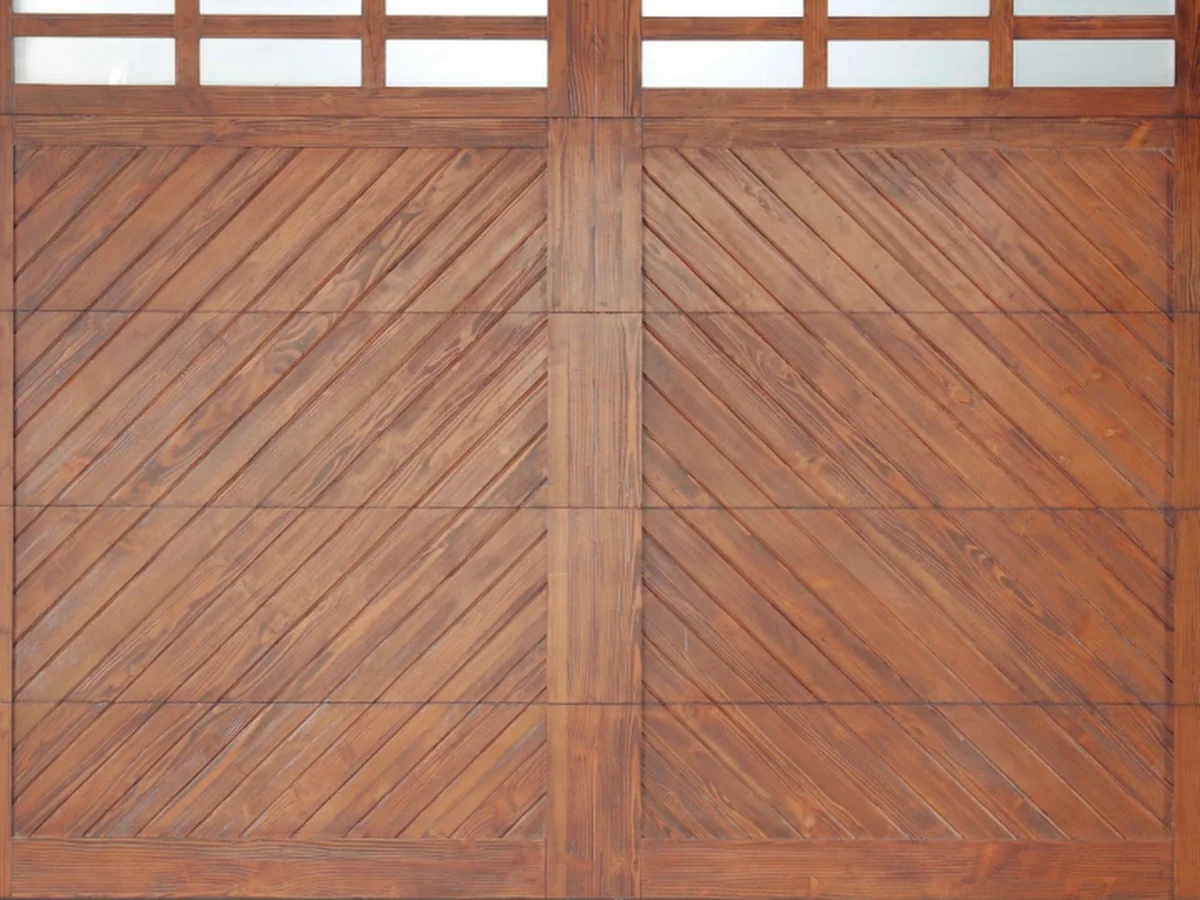 Carriage-house hinge detail across the wood clad garage door face, design rendering