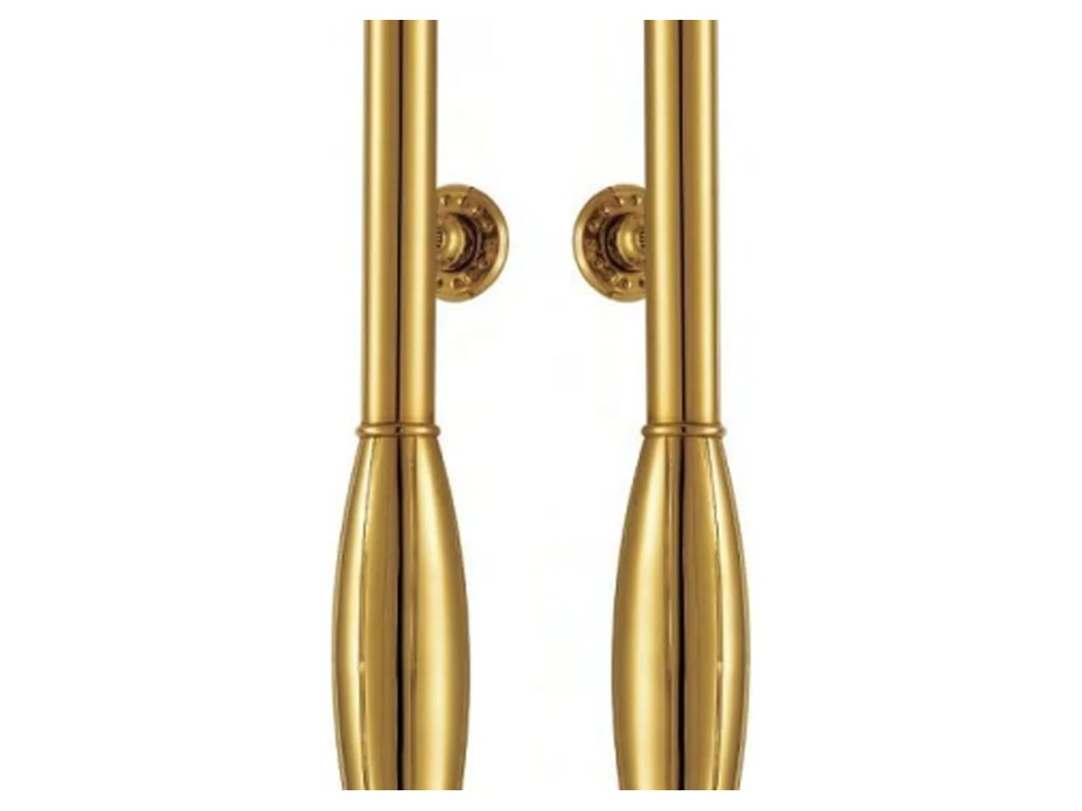 Close-up product shot of the carved decorative motif on the face of a brass door handle