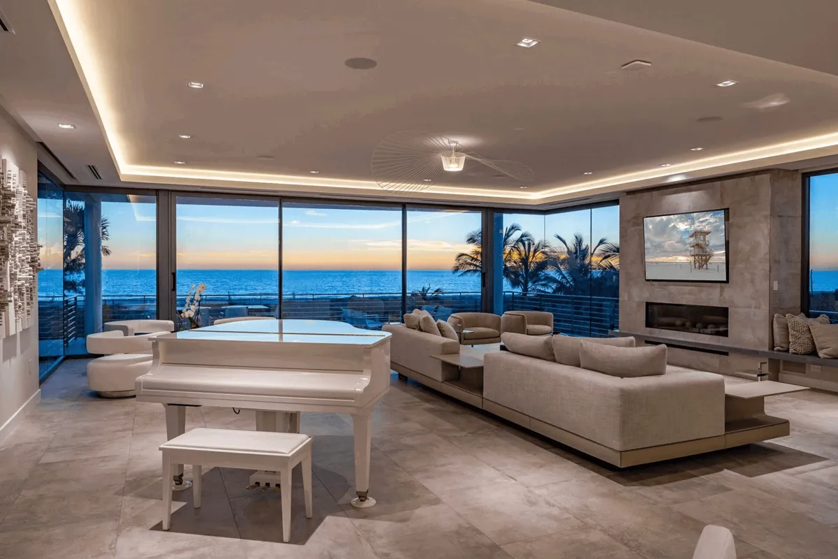 Penthouse living room with panoramic floor-to-ceiling glazing at sunset