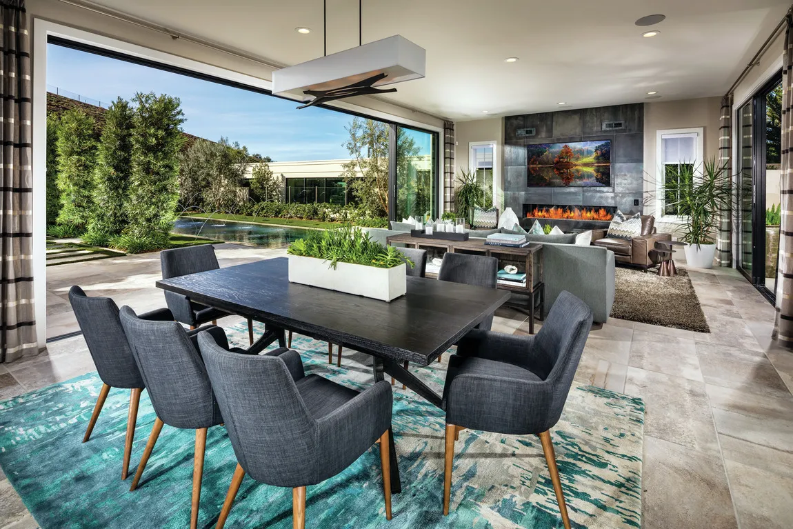 Open-plan dining and living room with a sliding glass wall onto a pool terrace